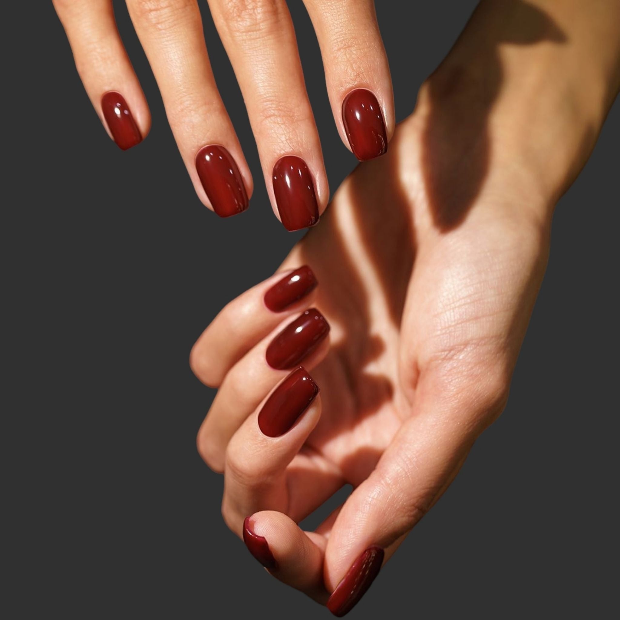 Close-up of hands with red nail polish on a dark background