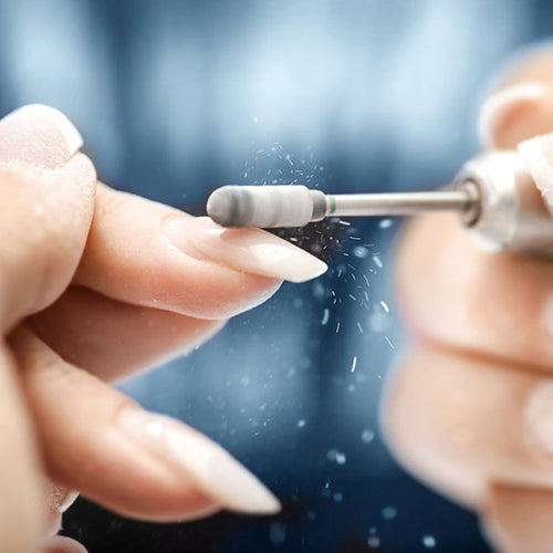 Close up image of acrylic nails and nail drill 