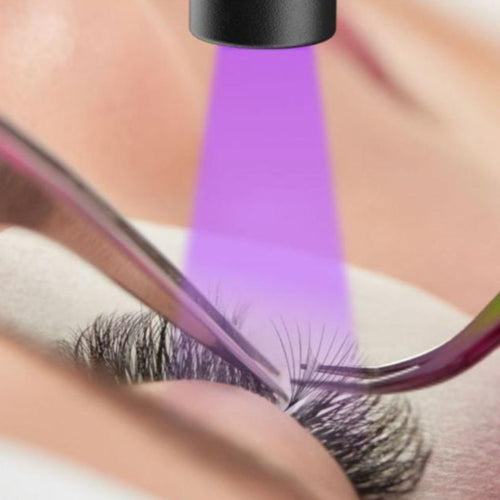 Eyelash extensions with LED light shining on the models eye.