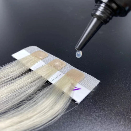 Hair extension with a dropper applying a liquid substance on a dark background