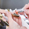 A person is receiving a manicure, focusing on the application of acrylic nail extensions.