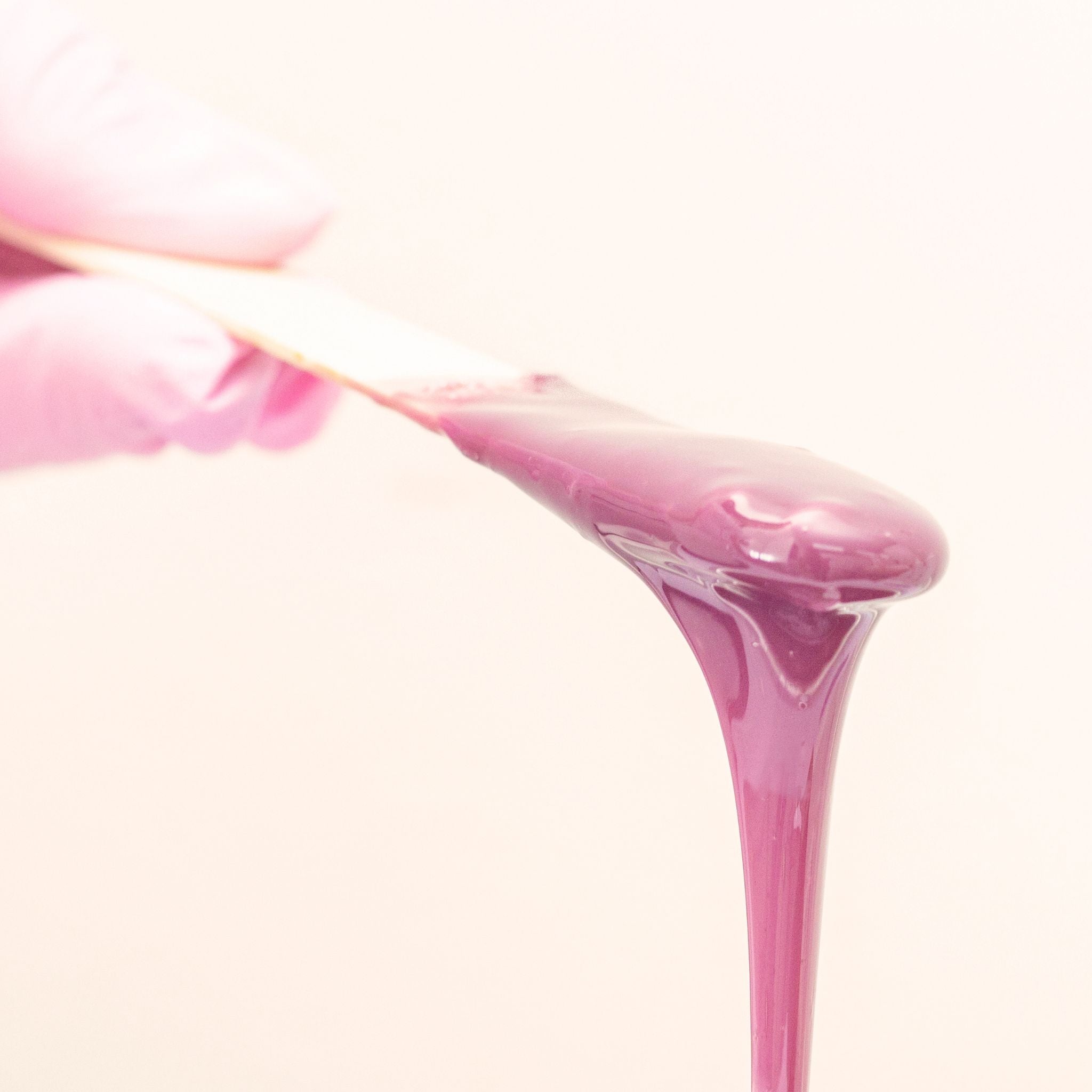 Close-up of pink liquid being poured with a white background